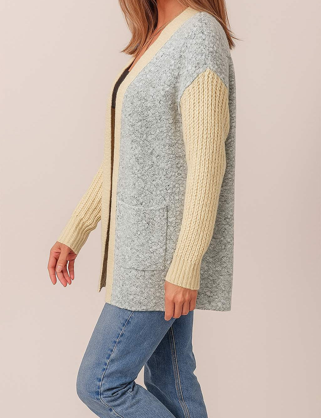 Left side view of the light-gray and pastel-yellow colorblock open-front cardigan showing the patch pocket opening, ribbed cuffs and straight hem.