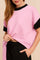 Front detail view of the pink and black colorblock textured short-sleeve top; elastic drawstring pants waistband visible.