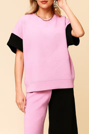 Front view of a pink and black colorblock textured top with matching wide-leg pants.