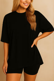 Plus size woman wearing an oversized black lounge set with round neck top and matching shorts