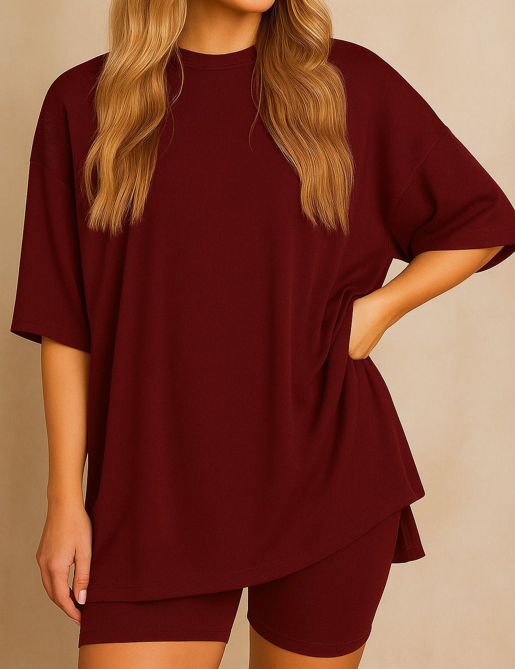 Plus size woman wearing an oversized burgundy lounge set with round neck top and matching shorts