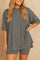 Plus size woman wearing an oversized grey lounge set with round neck top and matching shorts"