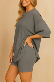 Side view of plus size woman wearing an oversized grey lounge set with relaxed fit top and matching shorts