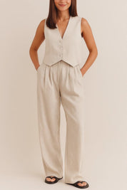 Front view of an apricot sleeveless V-neck vest and pleated wide-leg pants set with button closure and side pockets.