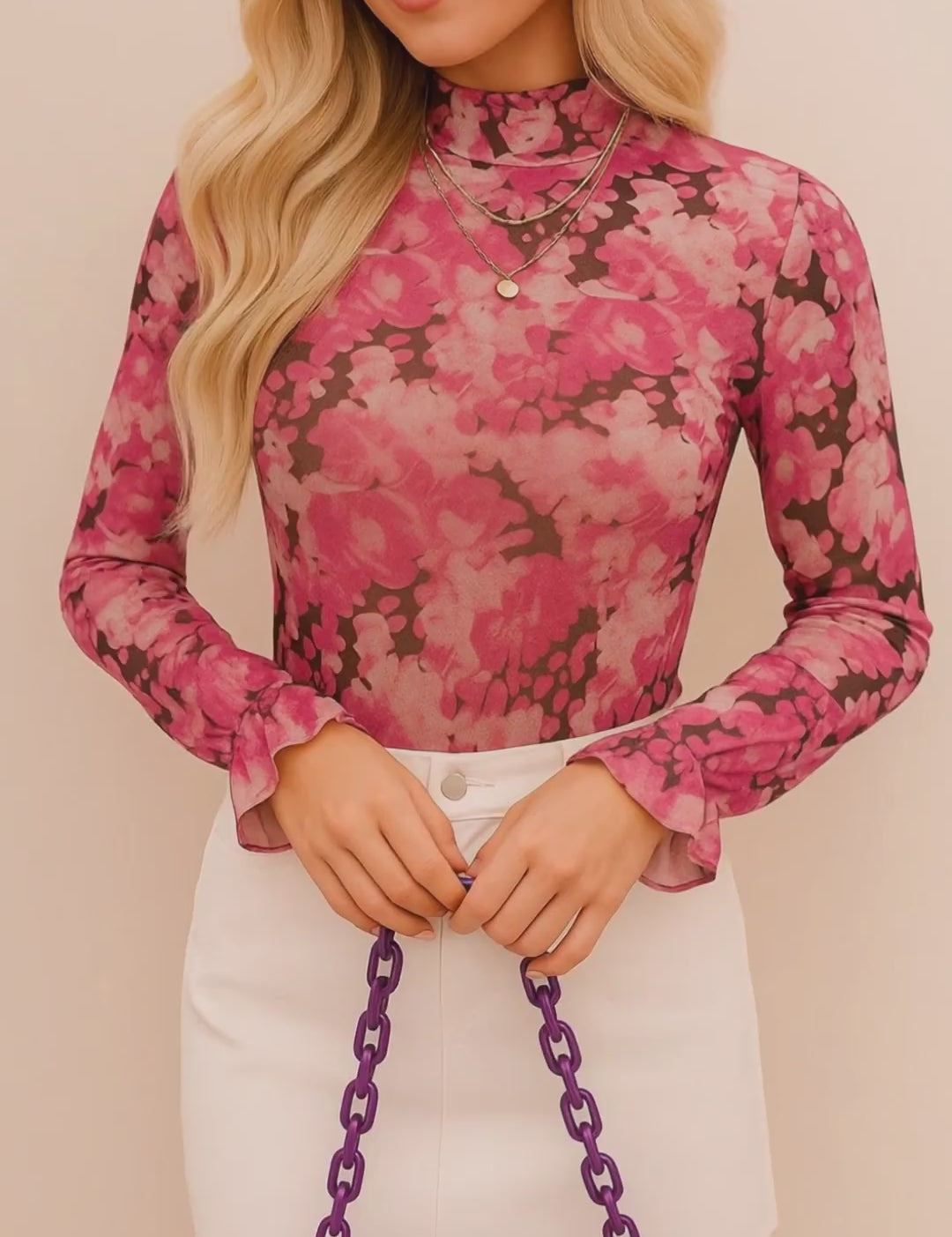 Short studio lookbook video of a pink floral mock-neck long-sleeve blouse with flounce cuffs, shown on-body.