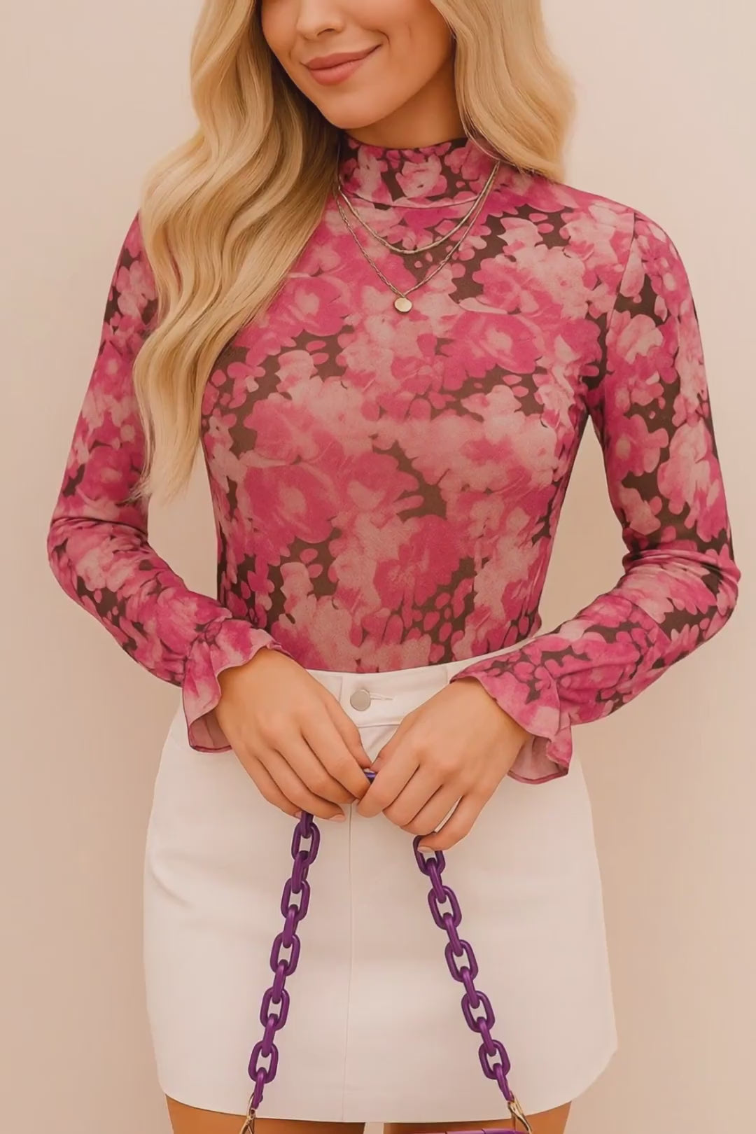 Short studio lookbook video of a pink floral mock-neck long-sleeve blouse with flounce cuffs, shown on-body.