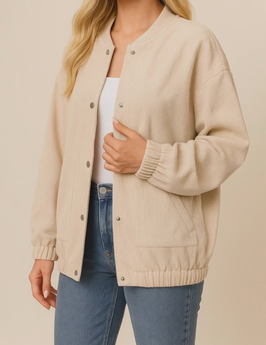Short lookbook video of a khaki corduroy snap-button jacket with rib-knit stand collar, drop-shoulder sleeves, elastic cuffs and slant welt pockets, shown in studio lighting.