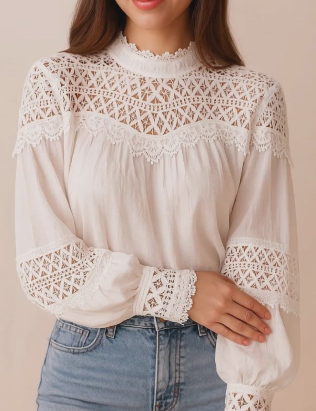 Short lookbook video of a white lace-yoke high-neck long-sleeve blouse with crochet trim and sheer lace inserts on the sleeves, shown in studio lighting