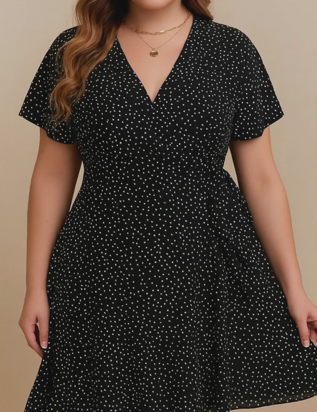 Plus-size black polka-dot wrap mini dress with V-neck, flutter sleeves and tie waist — studio lookbook video
