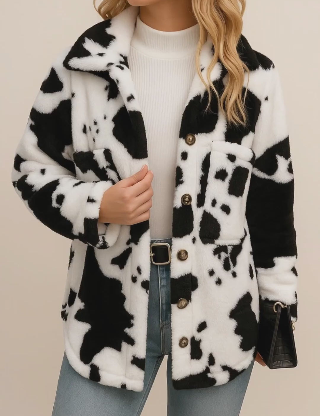 Short lookbook video of a white and black cow-print fuzzy button-up jacket with shirt collar and patch pockets, shown in studio lighting.