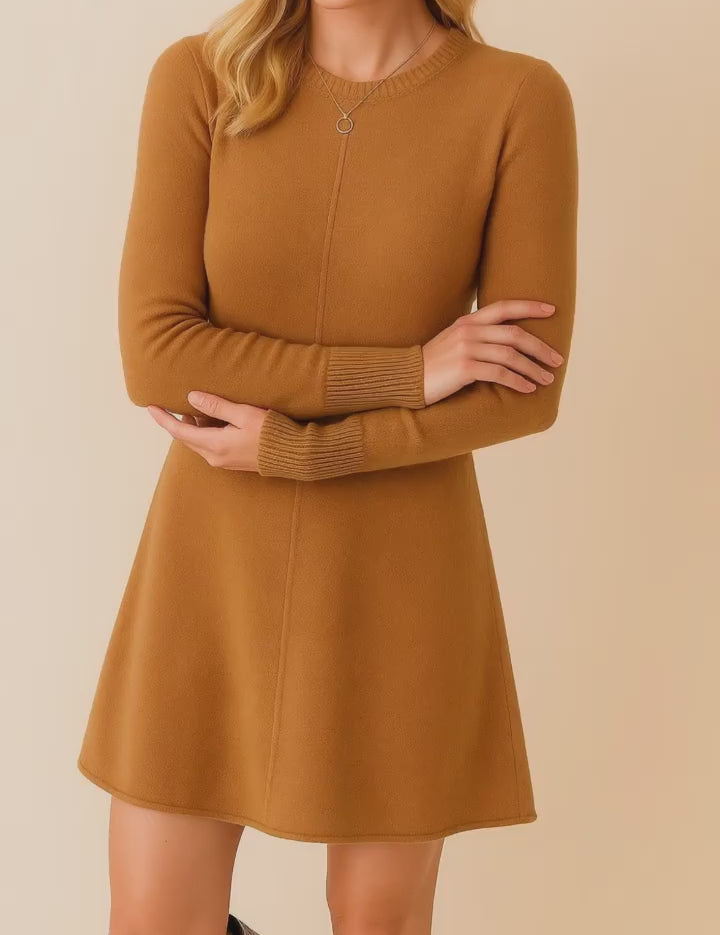 Short lookbook video showcasing a camel brown knit sweater dress with a crew neckline, long sleeves, clean center seam and soft A-line hem, shown from front, side and back in studio lighting.