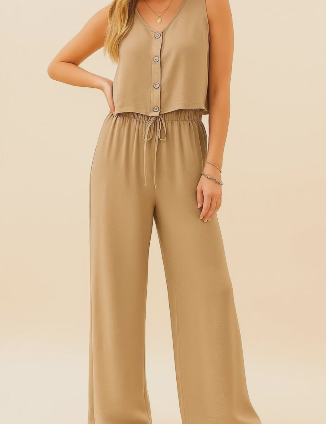 Short studio lookbook video of a camel two-piece set with a button-front V-neck tank and wide-leg drawstring pants shown on-body.