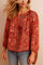 Front view of a women’s red-multi paisley blouse with a split tassel-tie neckline, gathered yoke, long sleeves with elastic cuffs and a straight hem