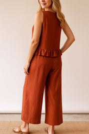 Back view of the rust ruffle-hem top and wide-leg pants set showing the straight back and cropped trouser length