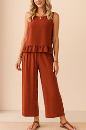 Centered front view of the rust sleeveless ruffle-hem top and matching wide-leg pants set with a relaxed drape.