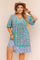 Plus-size sky-blue boho-print dress with lace-trim V-neckline, short sleeves and ruffled hem — front view.