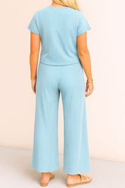 Back view of the sky-blue ribbed lounge set with a clean back panel on the top and relaxed drape through the wide-leg pants ending in a straight hem.