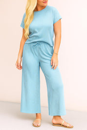 Two‑piece lounge set in sky blue — ribbed round‑neck short‑sleeve top with drawstring waist and relaxed wide‑leg pants — front three‑quarter view