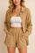 Front view of a women’s tan crinkle button-up shirt & shorts set with drop-shoulder long sleeves, elastic-waist shorts and side-seam pockets; shirt worn open.