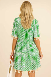 Turquoise geometric-print tassel-trim mini dress with gathered back waist and tassel hem — back view.