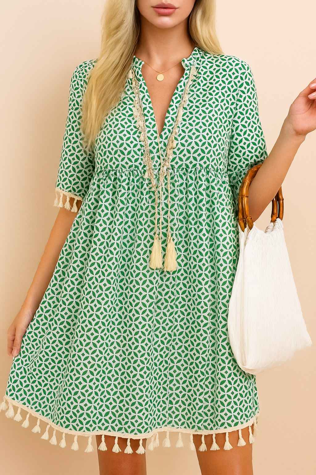 Turquoise geometric-print tassel-trim mini dress with gathered waist and tassel edges — centered front view.