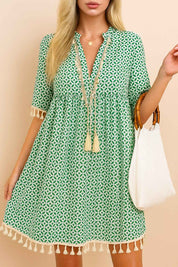 Turquoise geometric-print tassel-trim mini dress with gathered waist and tassel edges — centered front view.