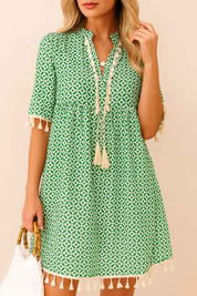 Turquoise geometric-print tassel-trim mini dress with short sleeves and relaxed A-line drape — front view
