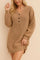 Close three-quarter front view of a women’s waffle-knit henley sweater dress with a V-neck and three-button placket, long balloon sleeves, ribbed cuffs and hem, and an easy above-knee fit.