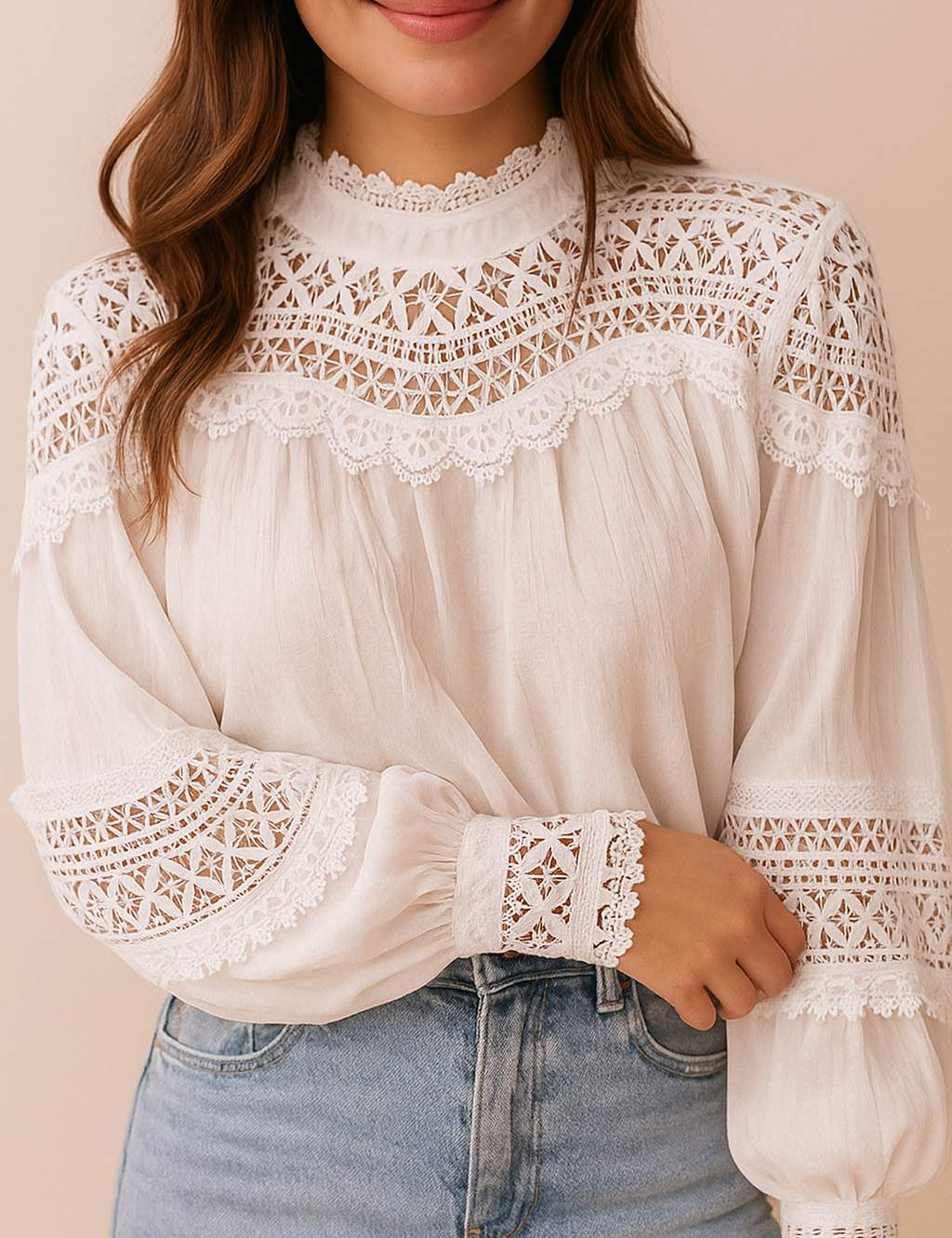 Close front detail of a women’s white lace-yoke high-neck long-sleeve blouse with crochet trim, scalloped edge and gathered balloon sleeves