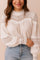 Close front detail of a women’s white lace-yoke high-neck long-sleeve blouse with crochet trim, scalloped edge and gathered balloon sleeves