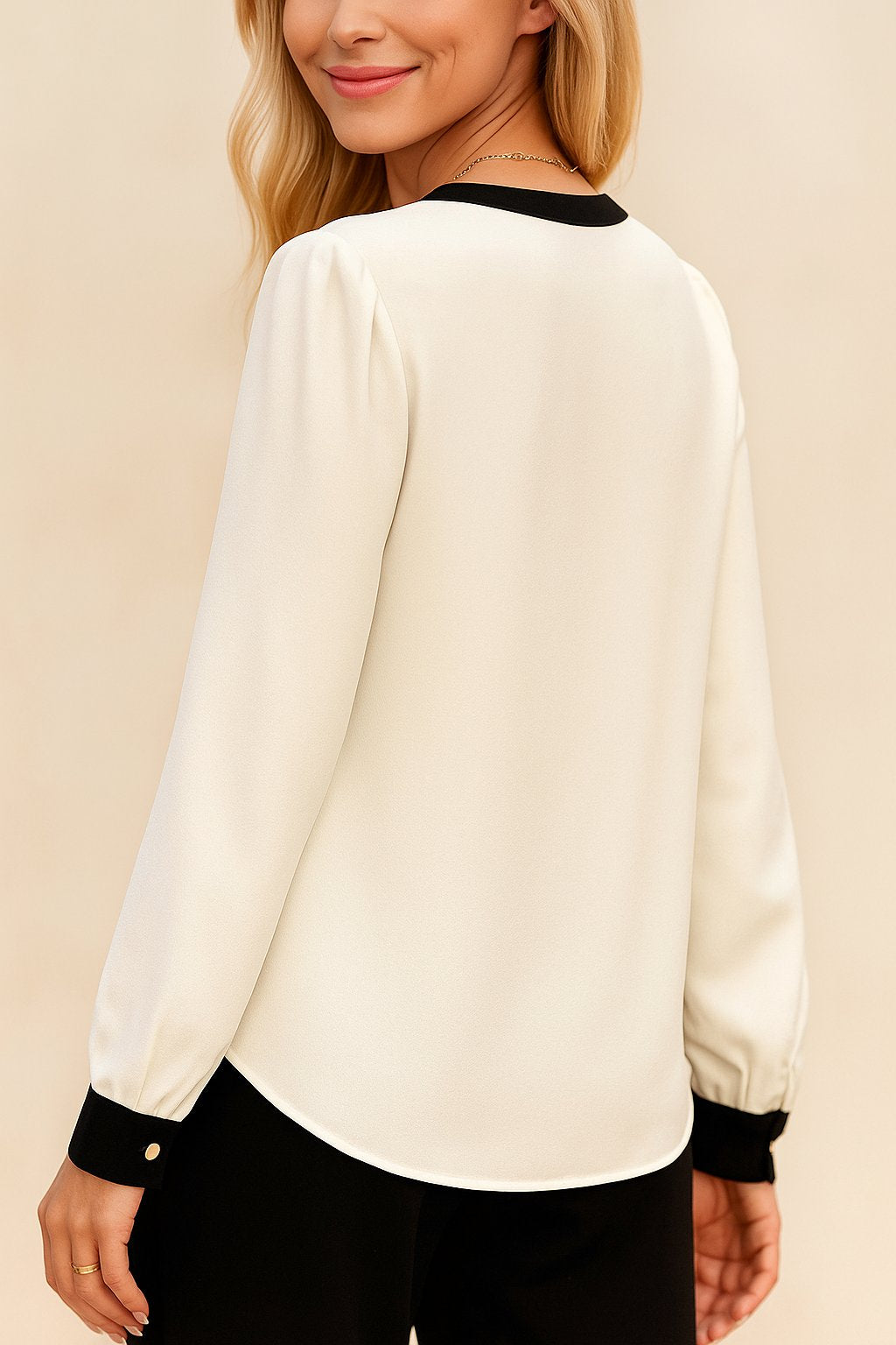 Back view of the white long-sleeve blouse showing the clean back panel, black contrast collar trim and curved hem