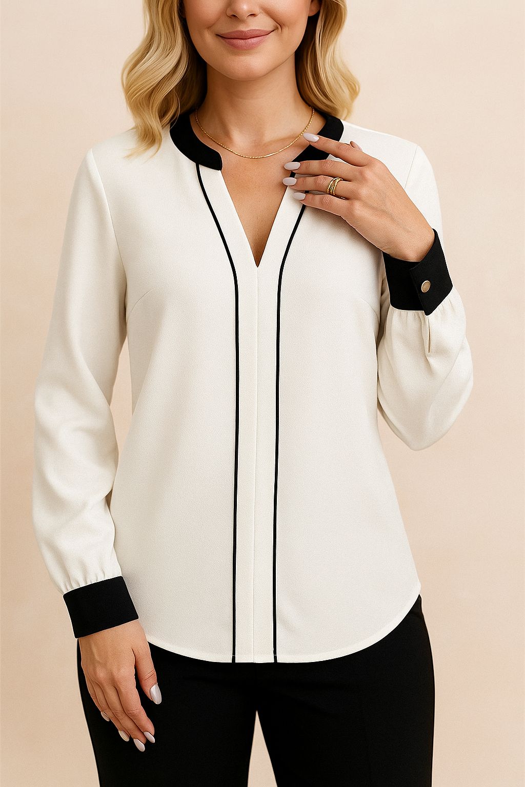 Centered front view of the white notched V-neck blouse featuring black contrast piping and button cuffs; rounded hem.