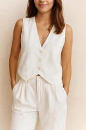 Front detail view of the white sleeveless vest and wide-leg pants set; V-neck and three-button closure