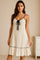 Women’s white tiered ruffled lounge dress with spaghetti straps, tie-front neckline and black contrast trim — front view.